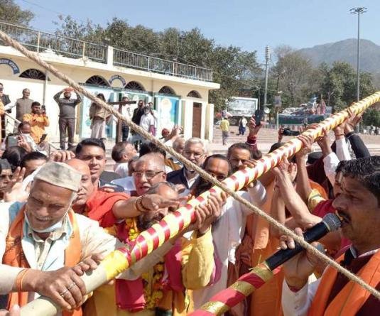 महाकुंभ को लेकर ऋषिकेश त्रिवेणी घाट पर डोली यात्रा की अगवानी करने वाले भगवान बदरी विशाल के ध्वज की स्थापना की